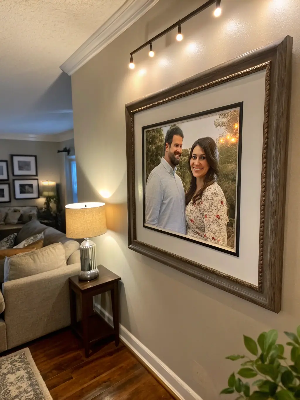 A high-quality photo of a digital photo frame displaying family photos, placed on a bedside table next to a cup of tea, in a warmly lit room.